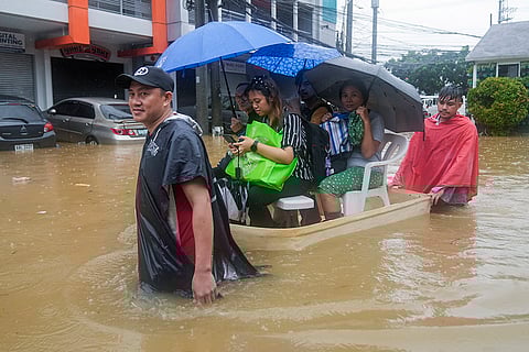 Philippines Tropical Storm Yagi: Residents ride on an improvised float through flood waters in Rizal province